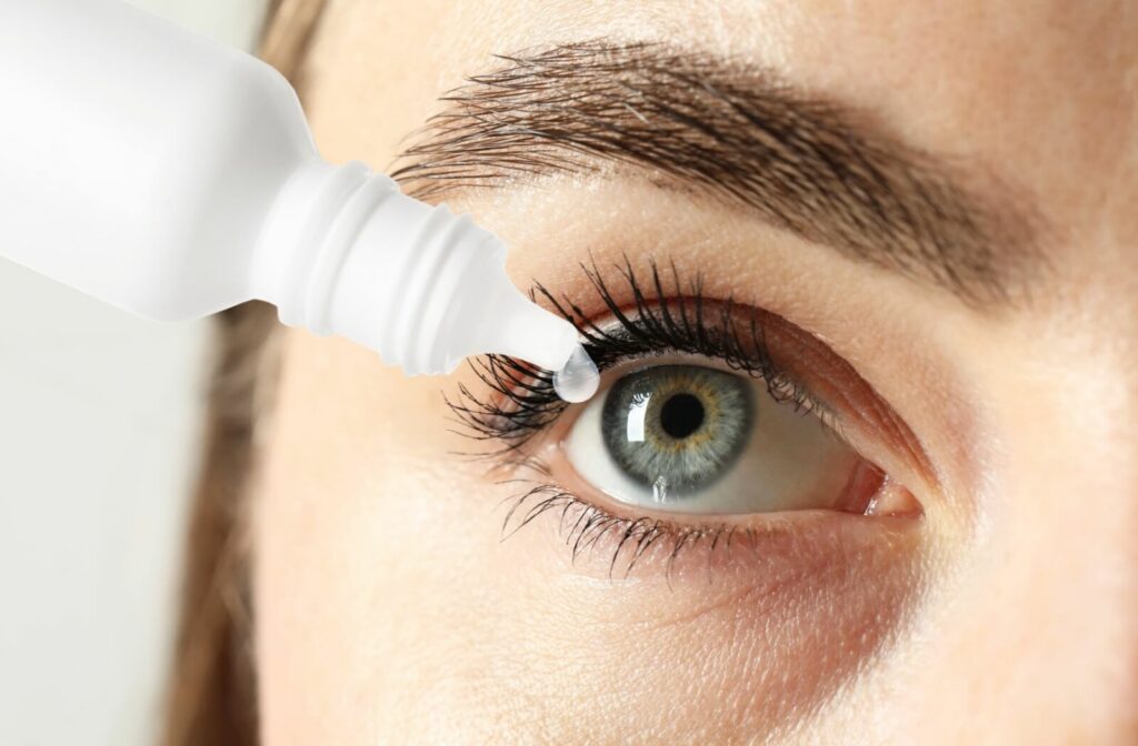 A close-up image of someone putting eyedrops in their eye to alleviate dry eye symptoms.